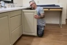 : Assemble painted cabinets Contractor reinstalling cabinet doors after painting for a complete and polished look